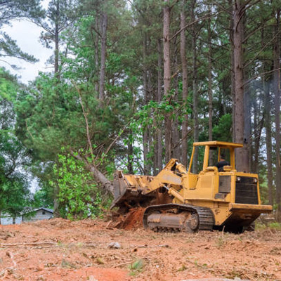 A construction site featuring a bulldozer and a digger, surrounded by dirt and construction materials.